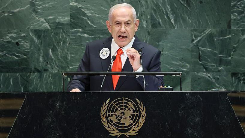 Izraelski premijer Benjamin Netanjahu govori na Generalnoj skupštini Ujedinjenih nacija (GA UN) održanoj u sedištu UN u Njujorku 26. septembra 2025. godine. Ima crno odelo sa narandžastom kravatom