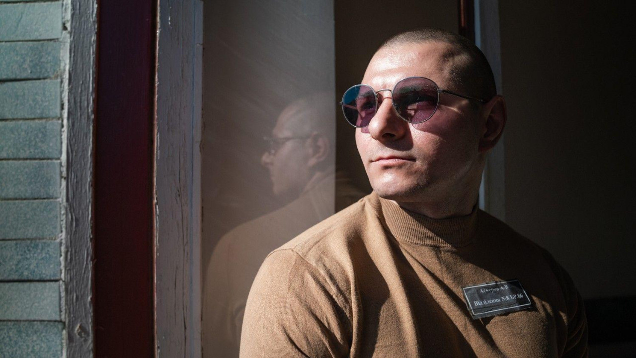 Andrej Askerov, ukrajinski zatvorenik sa naočarima i zatvorskoj uniformi gleda kroz prozor