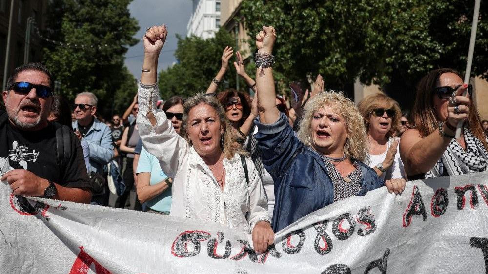 
                    žene sa uzdignutim pesnicama u Grčkoj, štrajk radnika u Grčkoj, Jednodnevni štrajk radnika u Grčkoj zbog vladinog predloga da poslodavci mogu da produže radno vreme do 13