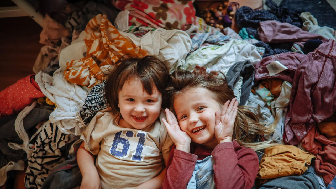 Brat i sestra se igraju na gomili garderobe