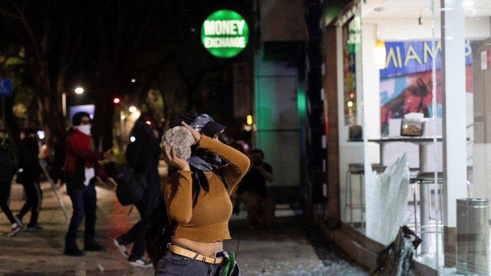 Demonstrantkinja baca kamen na prodavnicu tokom skupa solidarnosti sa Globalnom Sumud flotilom i Gazom u Meksiko Sitiju