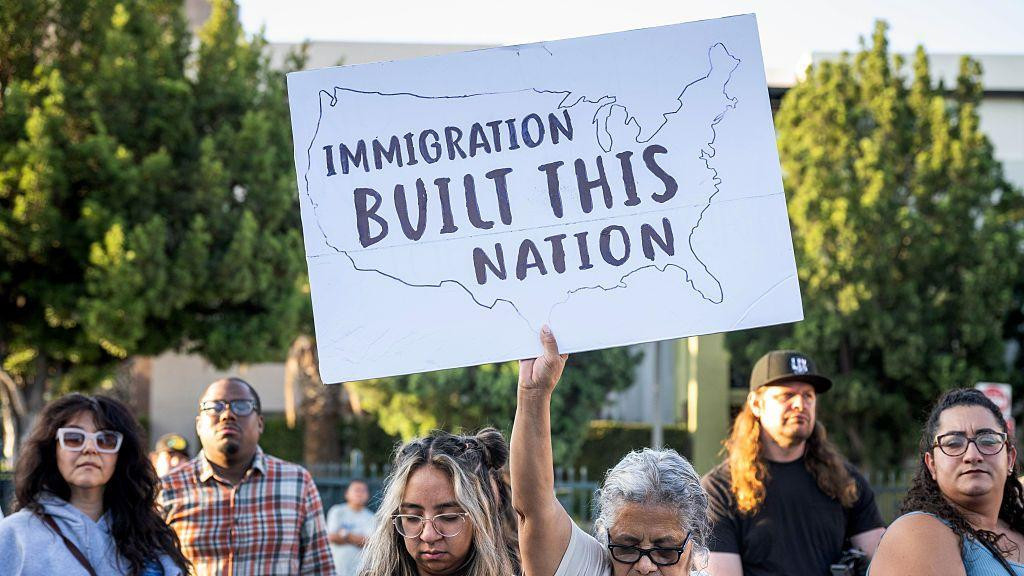 Protesti zbog akcija agenata ICE službe u Los Anđelesu. Žena drži transparent na kojem piše: 'Imigranti su izgradili ovu zemlju'