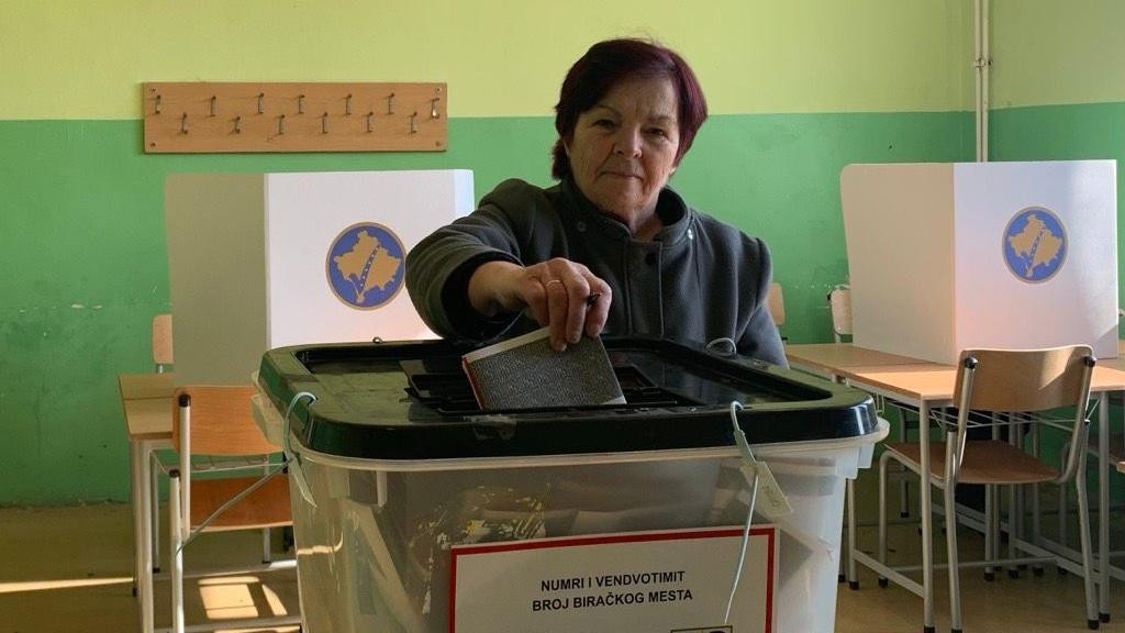 Žena ubacije glasački listić u plastičnu kutiju