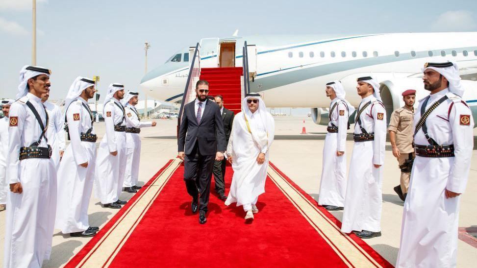 Sirijski predsednik Ahmed al-Šar hoda crvenim tepihom pošto je sišao sa aviona u Dohi 