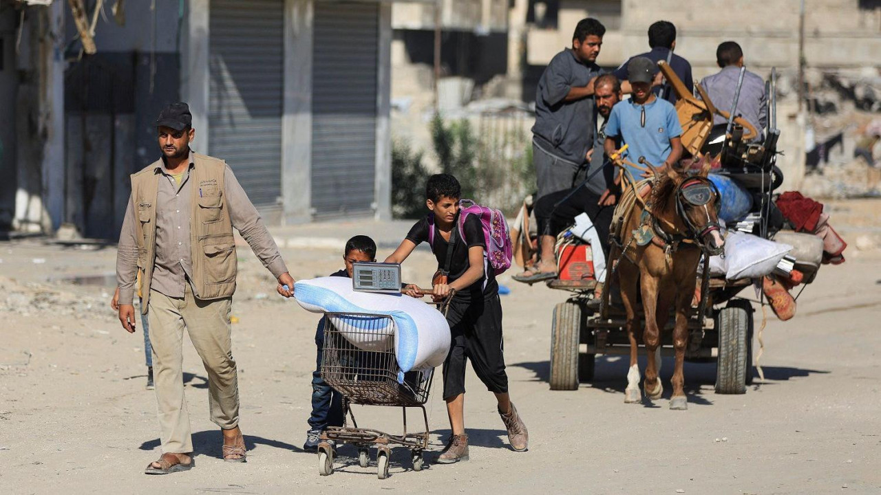 Palestinians, with their belongings, move along a street, amid a ceasefire between Israel and Hamas, in Gaza City, October 15, 2025. REUTERS/Dawoud Abu Alkas 