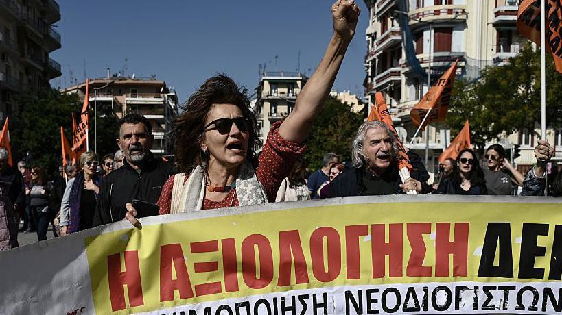 grupa ljudi nosi transparent na protestu u Grčkoj 