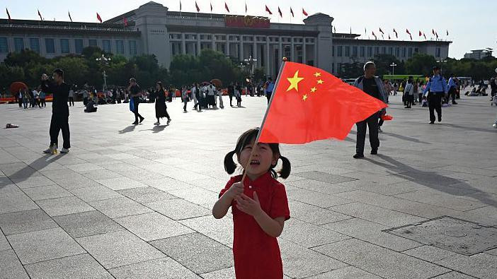 
                    Dete se igra držeći nacionalnu zastavu na Trgu Tjenanmen na Dan nacionalnosti Kine, koji obeležava 76. godišnjicu osnivanja Narodne Republike Kine, u Pekingu 1. oktobra 