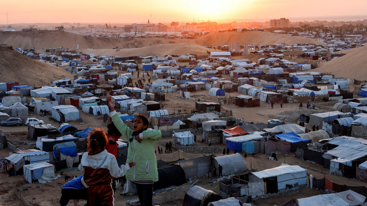raseljena palestinska deca na uzbrdici ispod koje je izbegličko šatorsko naselje 