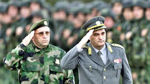 Muškarac u maskirnoj uniformi salutira, Pavković u svečanoj vojnoj uniformi takođe salutira