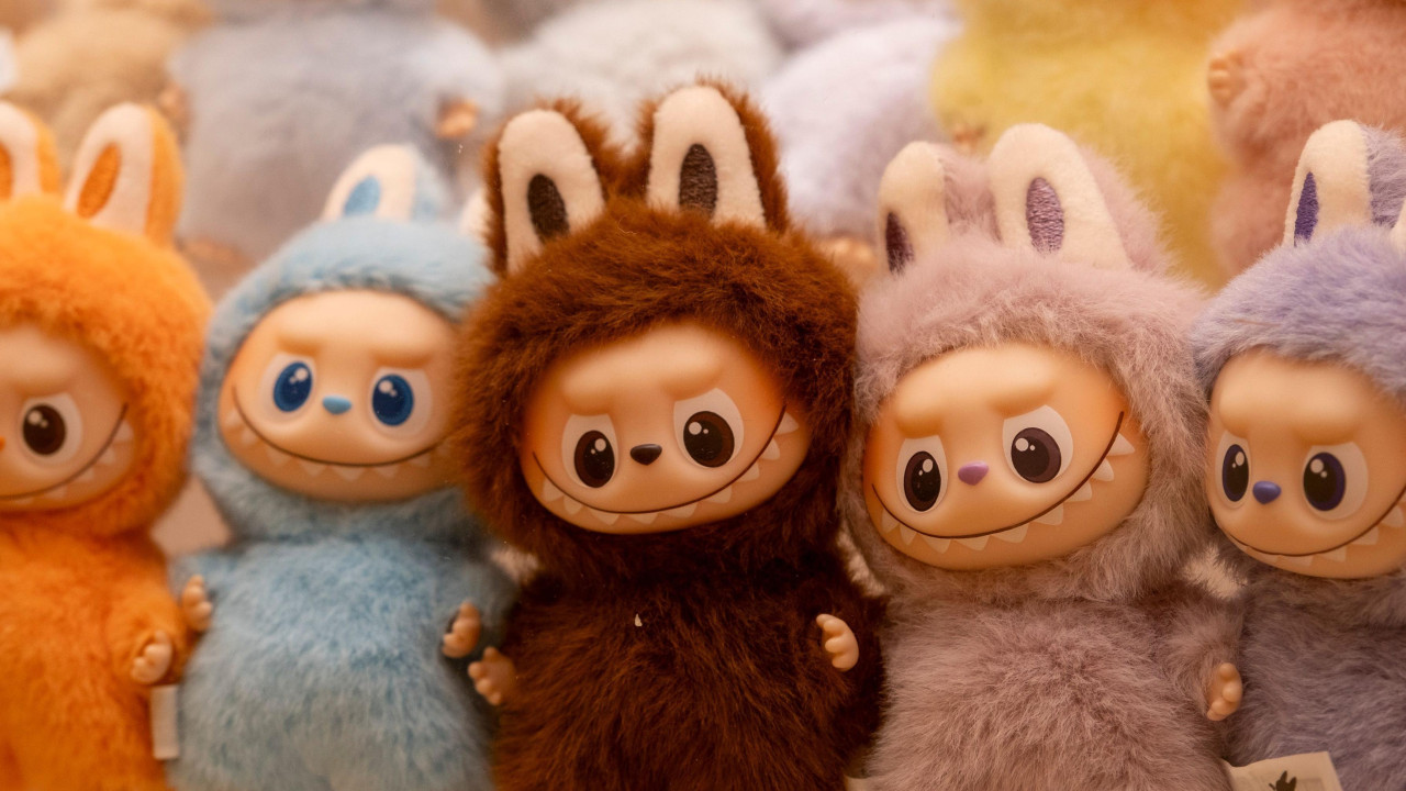 Više lutaka Labubu raznih boja koje imaju lice čudovišta, osmeh sa širokim zubima i velike oči