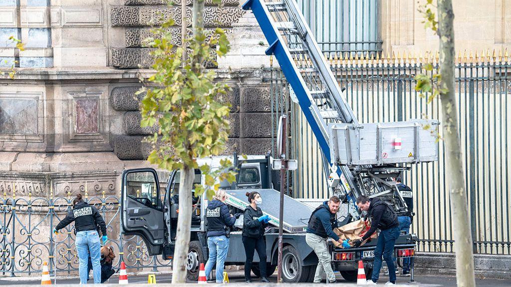 French forensic police are collecting evidence at the crime scene next to the truck used in the Louvre Museum heist.
