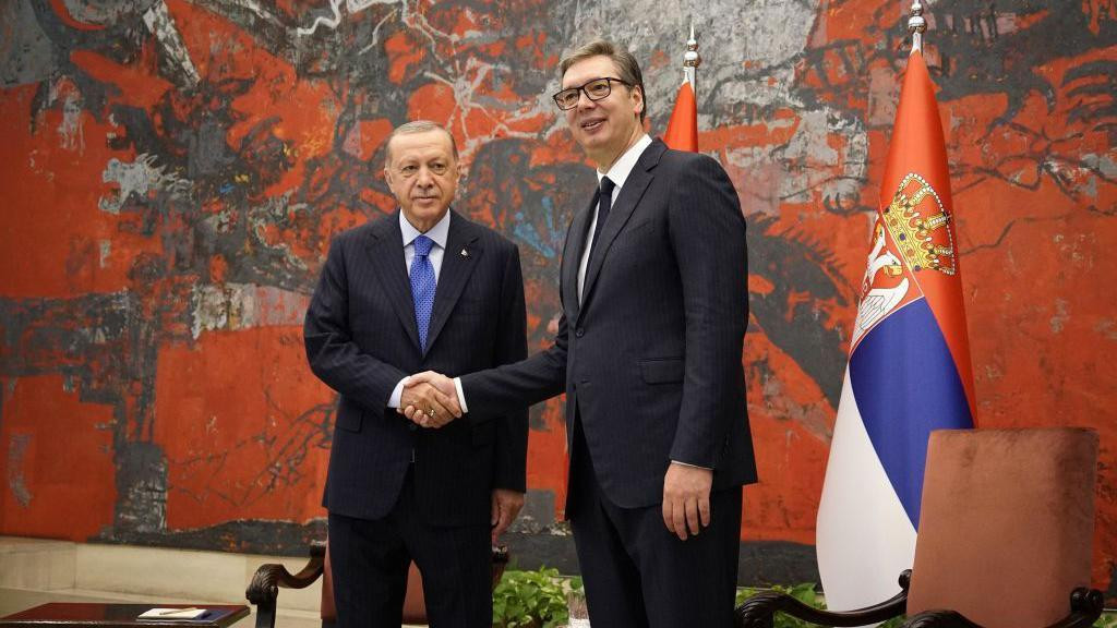 Erdoğan ve Vucic el sıkışıyor yanlarında Sırbistan bayrağı ve koltuklar var. 