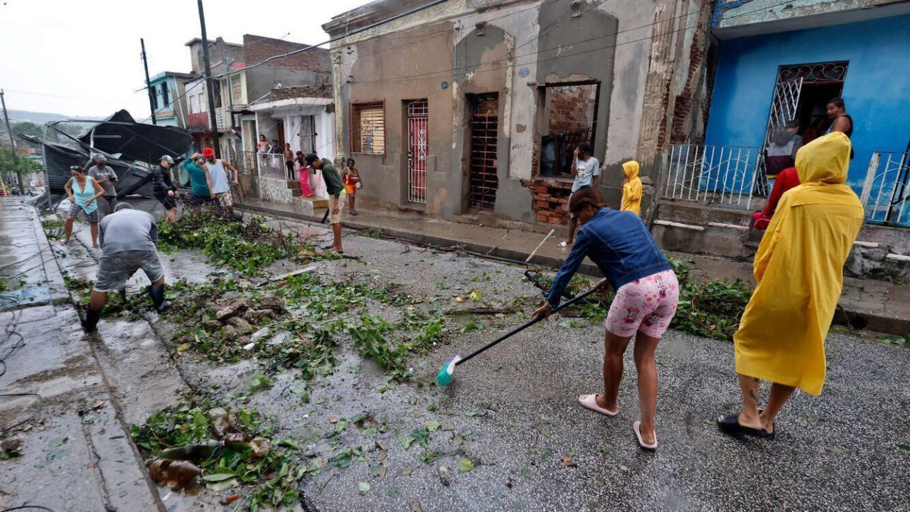 Nekoliko ljudi čisti ulice i rasklanja polomljeno granje posle uragana na Kubi