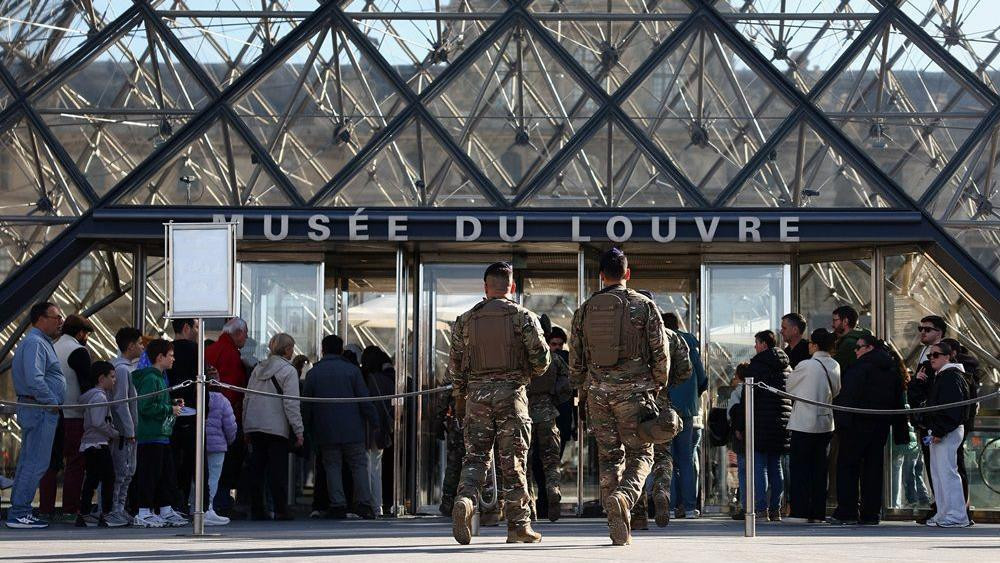 muzej luvr, pljačka u luvru, opljačkan muzej luvr, Francuski vojnici iz bezbednosnog plana „Sentinel“ patroliraju pored staklene piramide dok ljudi čekaju u redu za ulazak u muzej Luvr