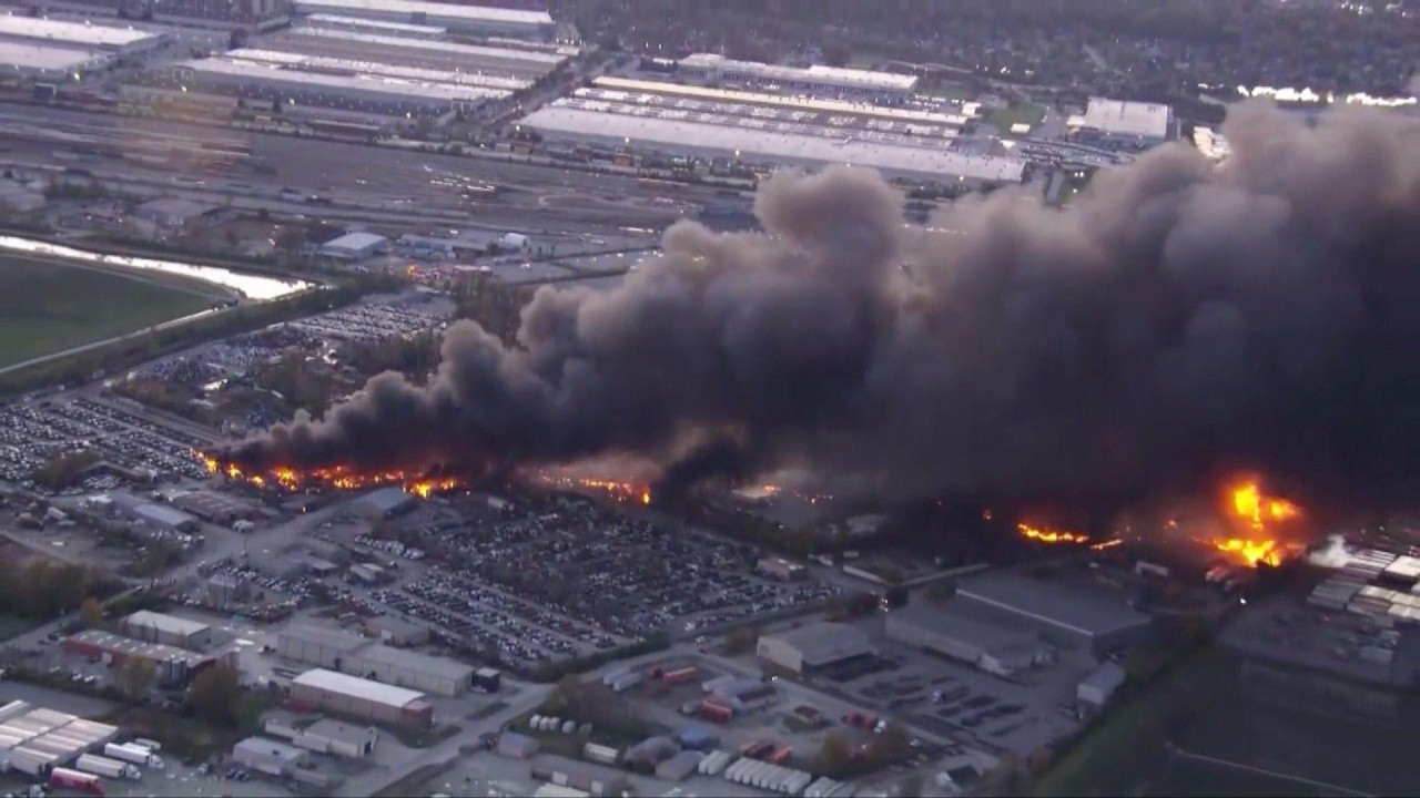 Smoke and flames billow into the sky above a plane crash site in Louisville.