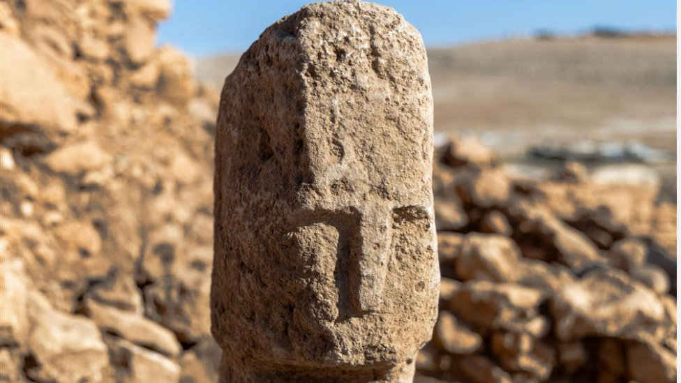 A T-shaped pillar bearing a carved human face