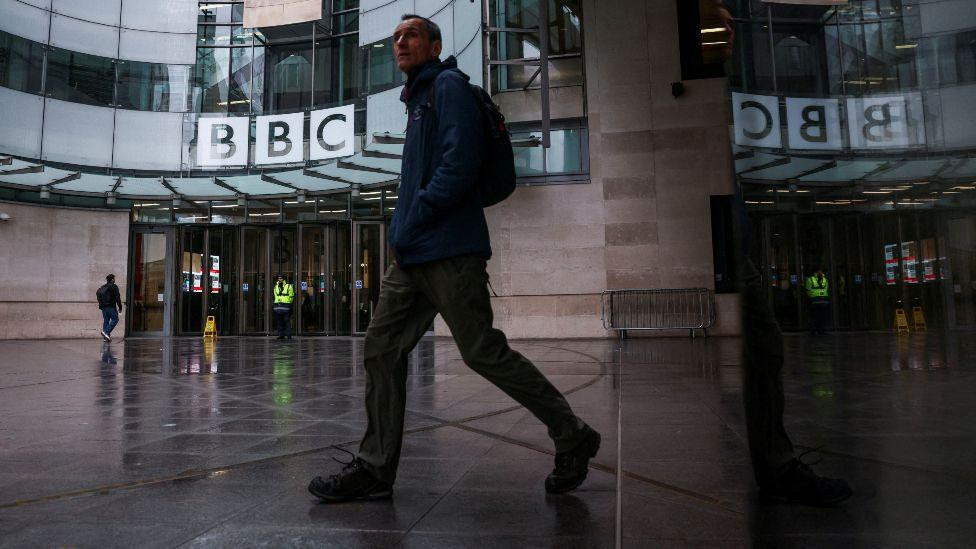čovek prolazi pored zgrade BBC-ja u Londonu