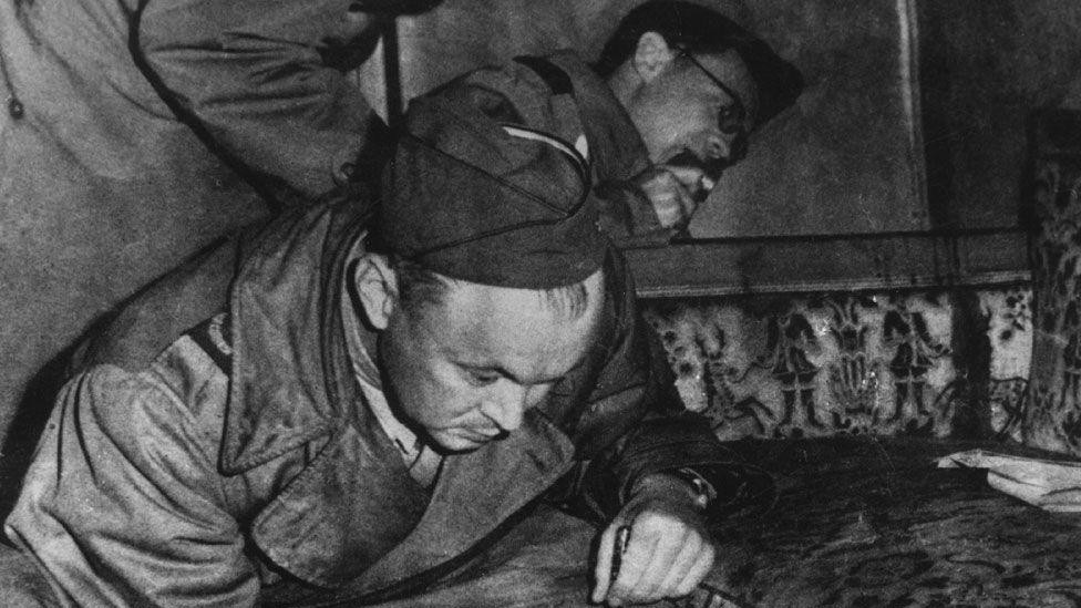 Saveznički ratni novinari ispituju sofu u Hitlerovom bunkeru 1945. godine - kaže se da je mrlja na naslonu fotelje krv. 