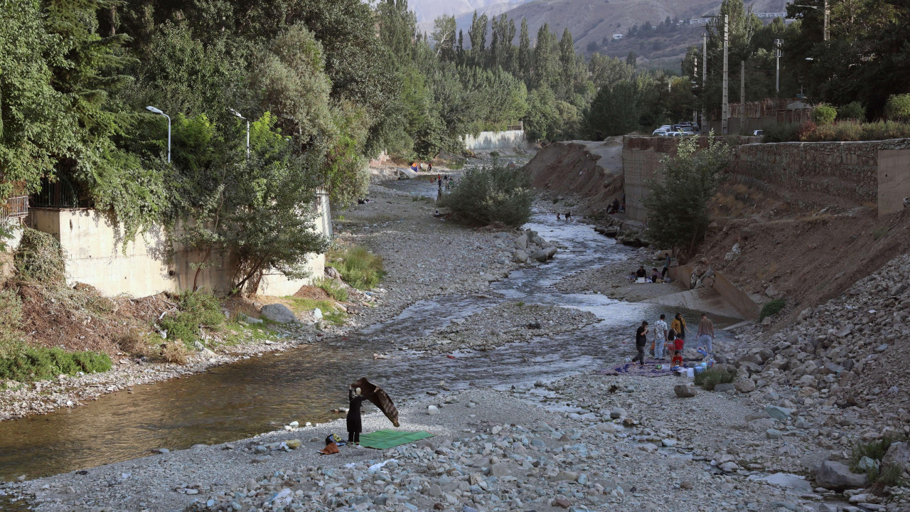 Ljudi šetaju i odmaraju pored rečice u Iranu