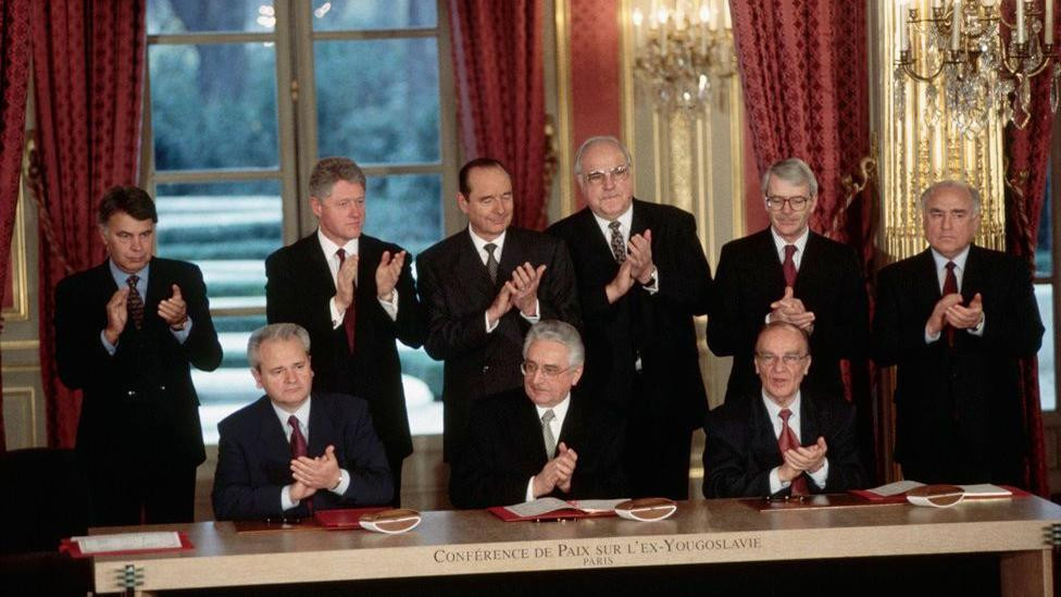 
                    Srpski predsednik Slobodan Milošević, hrvatski predsednik Franjo Tuđman i bosanski predsednik Alija Izetbegović sede ispred svojih primeraka sveže potpisanog Dejtonskog