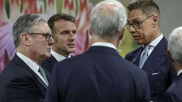 muškarci u odelima i belim košuljama, jedan je okrenut leđima 