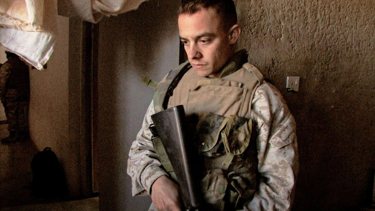 muškarac u vojnoj odeći sa puškom gleda u pod 