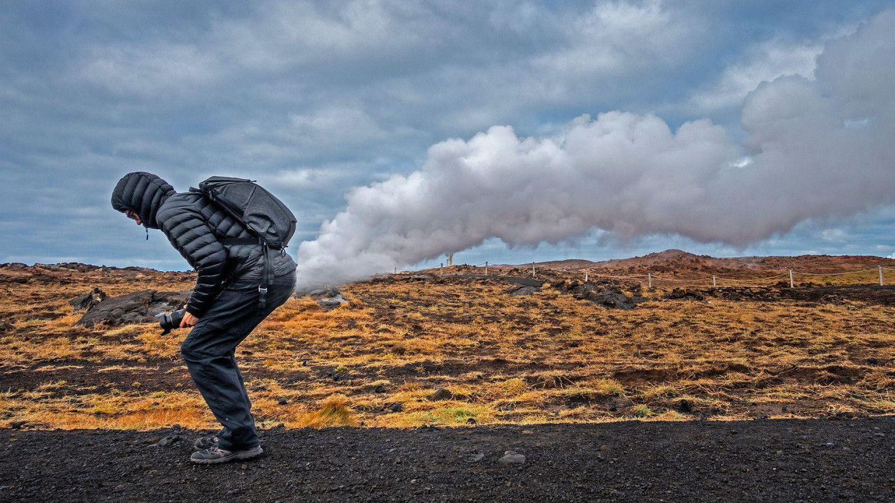 
                    Fotografija prikazuje čoveka u kratkoj perjanoj jakni sa kapuljačom na glavi, u pantalonama i cipelama za planinarenje. Postavio se tako da izgleda kao da mu oblaci izlaz