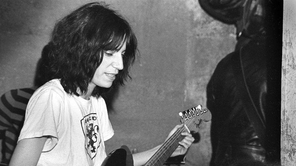 Peti Smit vežba gitaru u bekstejdžu na Long Ajlendu u Njujorku (1975)