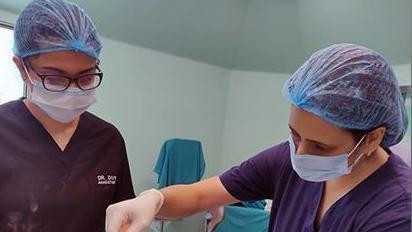 Dve medicinske sestre i jedna pacijentkinja na stolu sa slušalicama na ušima
