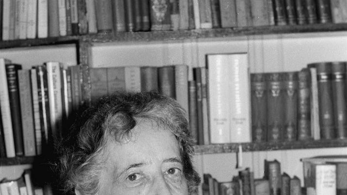 Crno-bela fotografija starije žene koja u jednoj ruci drži naočare za vid 