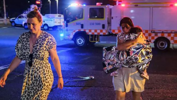 Majka nosi dete sa plaže Bondi u Sidneju