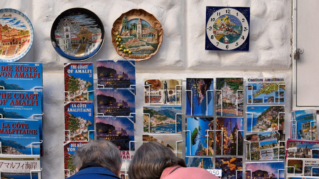 Ljudi ispred sštanda sa razglednicama 