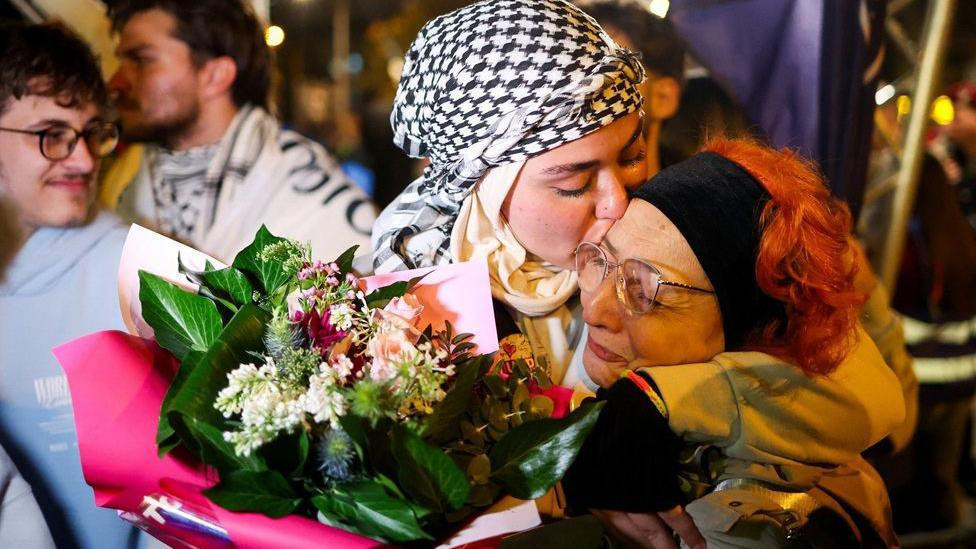 Godišnjica pada nadstrešnice, devojka sa hidžabom sa cvećem u rukama ljubi stariju ženu na dočeku u Novom Sadu