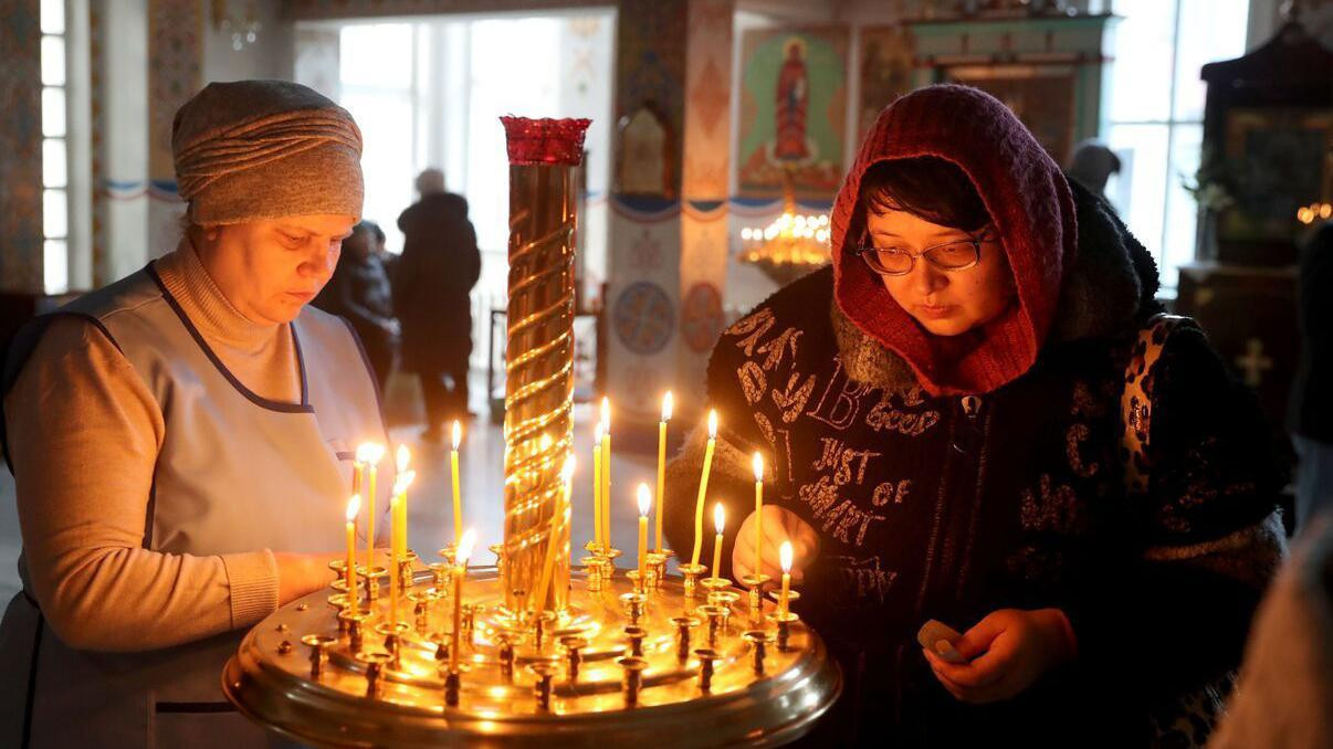 Dve žene pale sveće 