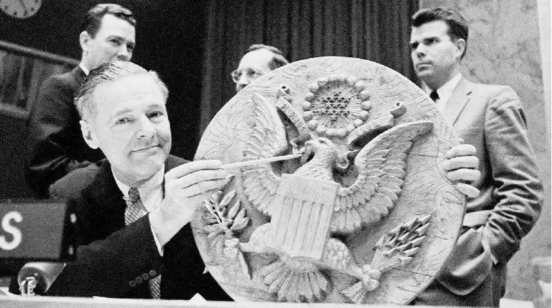 United States Representative to the United Nations, Henry Cabot Lodge, points to the spot on the seal where it has been bugged, the image is black and white.