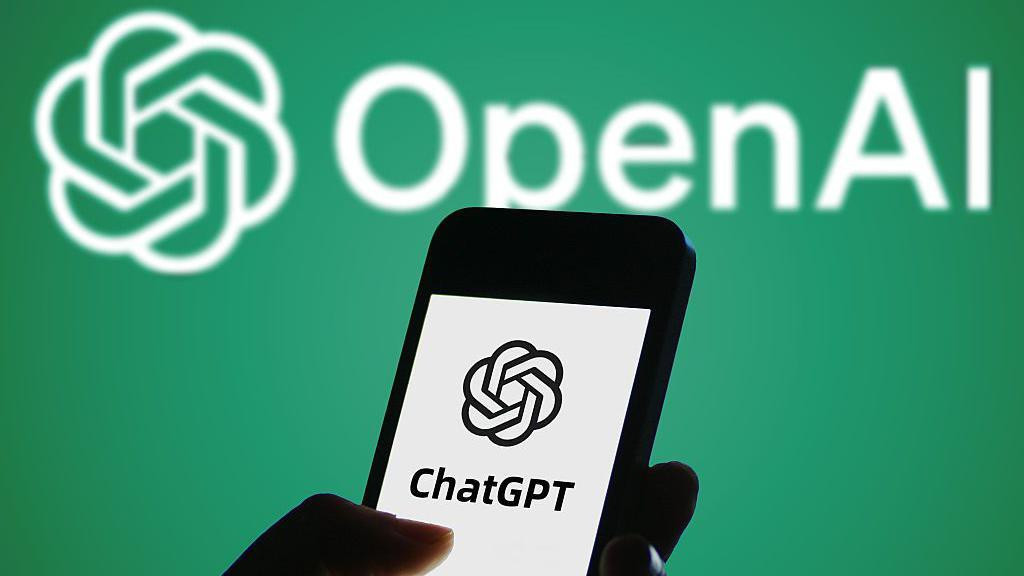 Ruka koja drži telefon na kom je ČetGPT logo