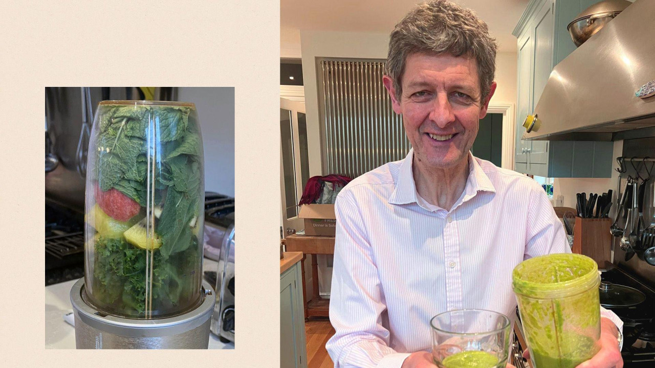 muškarac sedei u kuhinji i drži čašu sa zelenim napitkom 