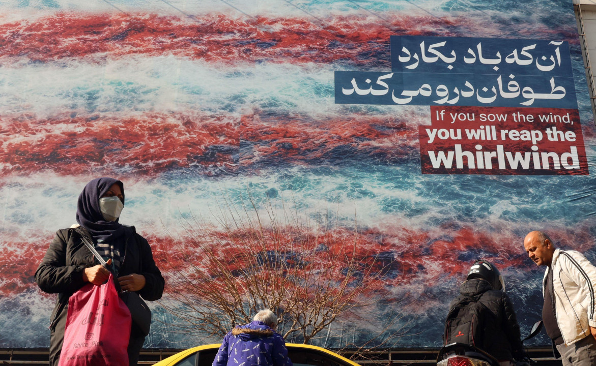 iran i amerika, iranci prolaze pored velikog bilborda na kojem piše: Ako pošalješ vetar, požnjećeš vihor