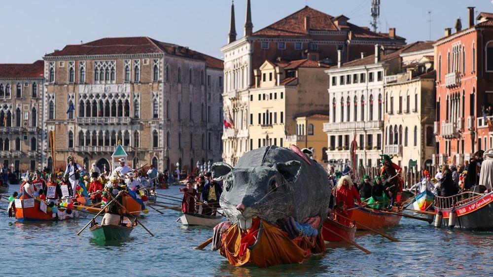 Čamac prevozi „Panteganu“, velikog pacova, preko Velikog kanala tokom Venecijanskog karnevala