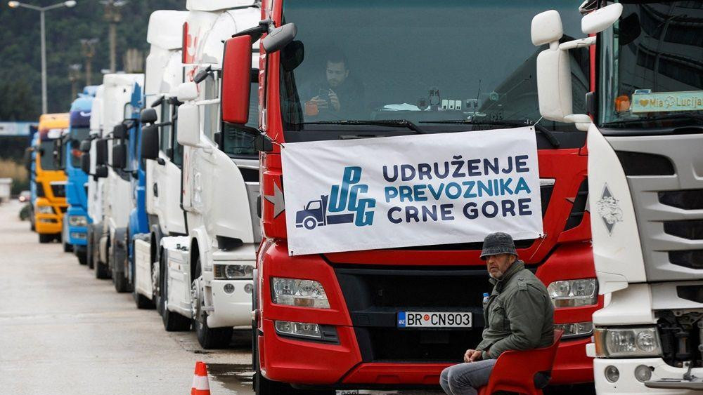 kamiondžije, crnogorski kamioni, crnogorske kamiondžije, vozač kamiona sedi pored desetine vozila parkiranih ispred Luke Bar