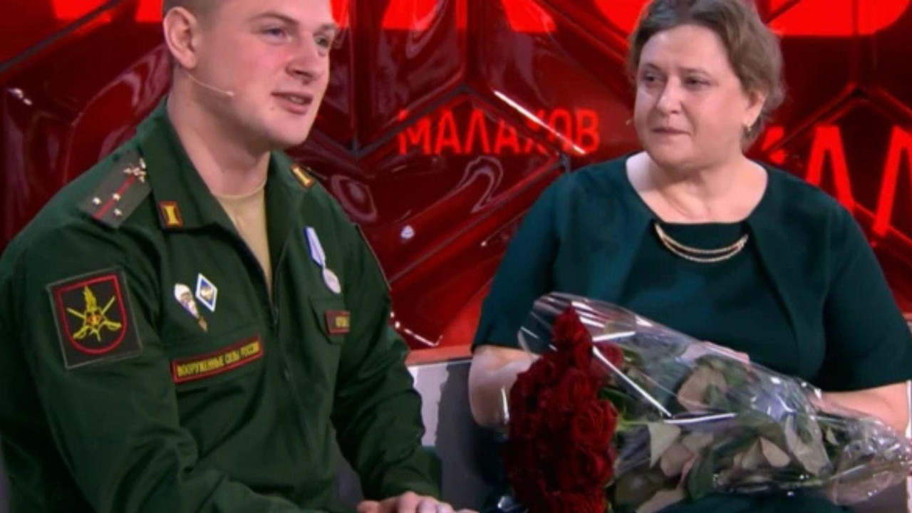 Muškarac sedi pored žene u studiju