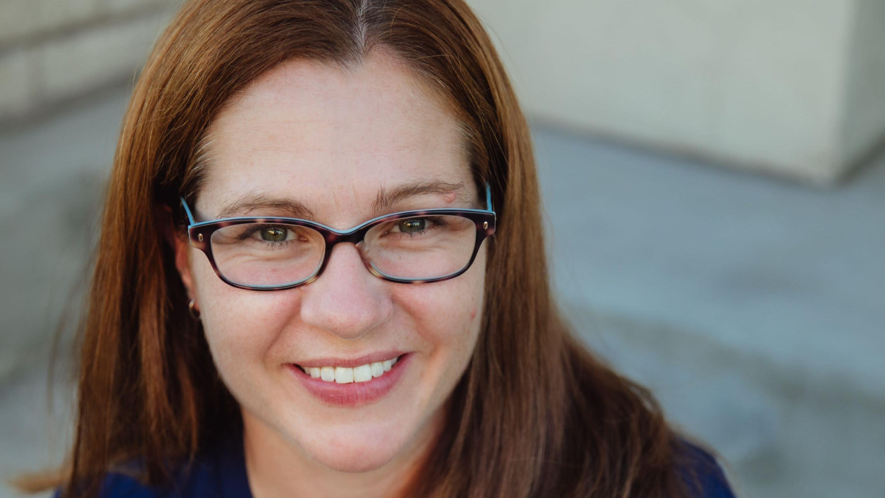 žena sa naočarima gleda u kameru i smeška se