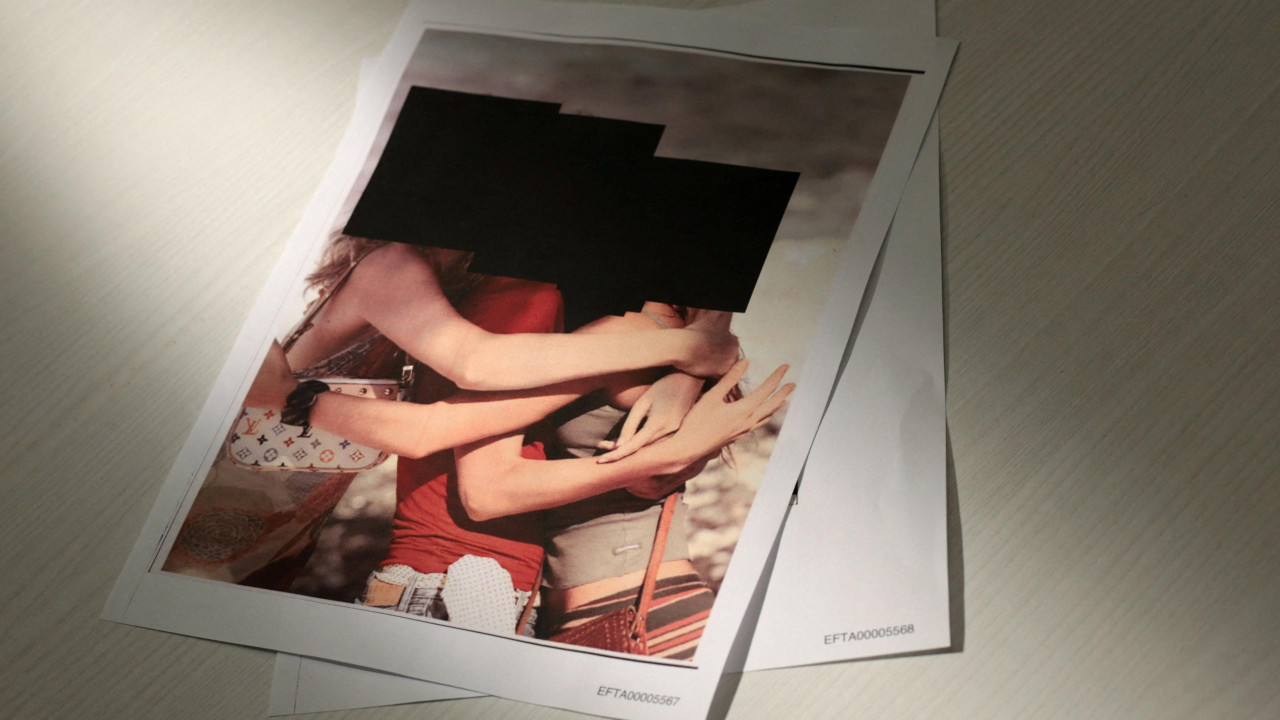 Tri žene se grle na jako redigovanoj fotografiji, lica su im zatamnjena