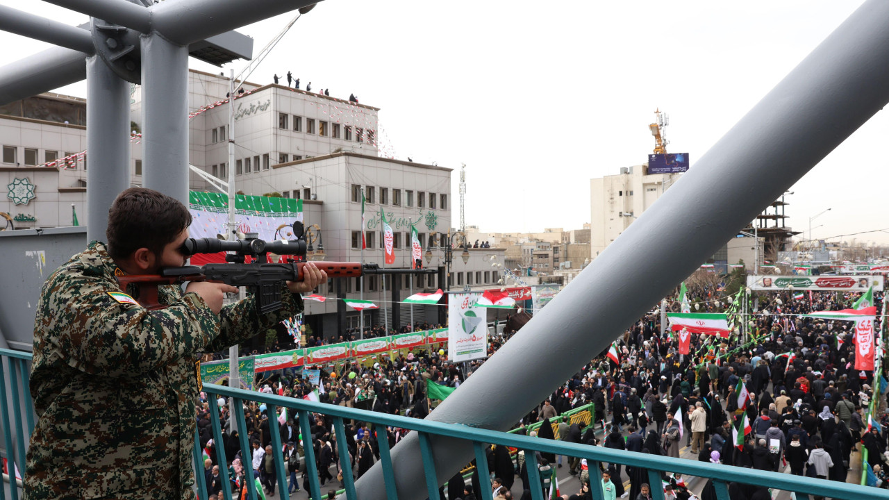 muškarac u maskirnoj uniformi sa snajperom nagleda proslavu 47. godine Islamske Republike Iran u Teheranu