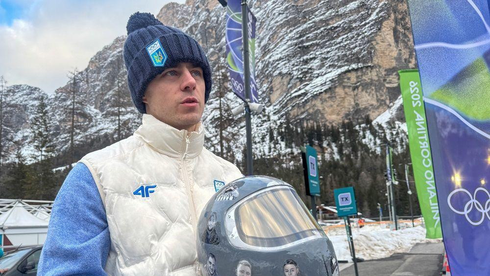 Ukrajinski skeletonac Vladislav Geraskevič drži kacigu sa slikama svojih sunarodnika poginulih tokom rata u Ukrajini