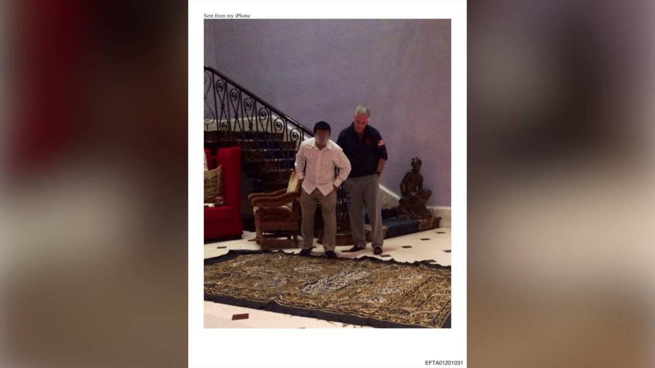Fotografija iz dosijea Ministarstva pravde SAD-a na kojoj su čovek koji izgleda kao Džefri Epstin i još jedan muškarac koji stoje jedan pored drugog i posmatraju komad bogato ukrašene tkanine na zemlji