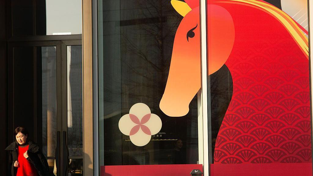 Žena ispred crteža crvenog konja 