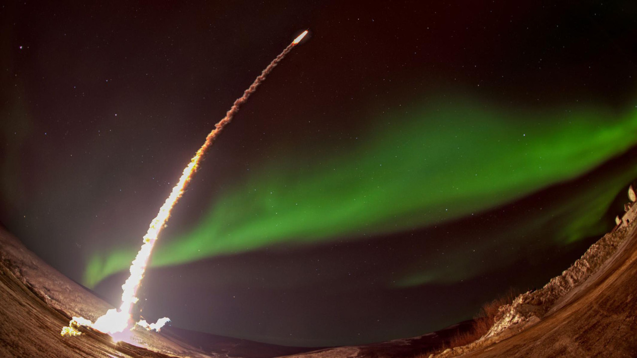 Lansiranje noćne rakete sa polarnom svgetlošću u pozadini  