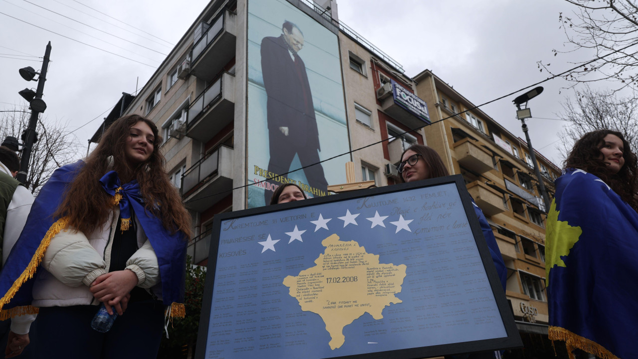 Devojke ogrnute kosovskim zastavama stoje pored panela sa imenima žrtava srpskog režima tokom proslave 18. godišnjice nezavisnosti zemlje u Prištini, Kosovo, 17. februara 2026. 