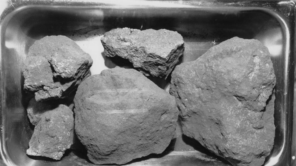 Several grey rocks of different sizes are sitting in a metal tray. 